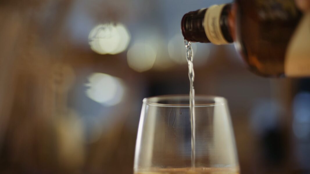 Μπουκάλι ουίσκι που γεμίζει ένα ποτήρι. Στιγμιότυπο από προϊοντικό Video.
